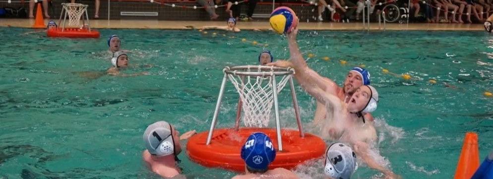 Man scoort in een waterbasket waarbij hij wordt verdedigd door de tegenpartij