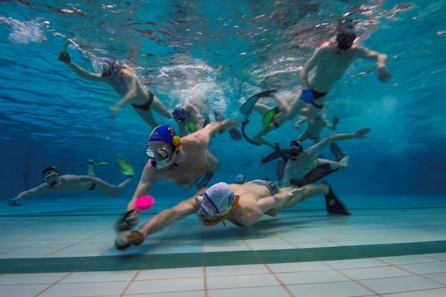 Twee onderwaterhockeyers die proberen de puck te veroveren